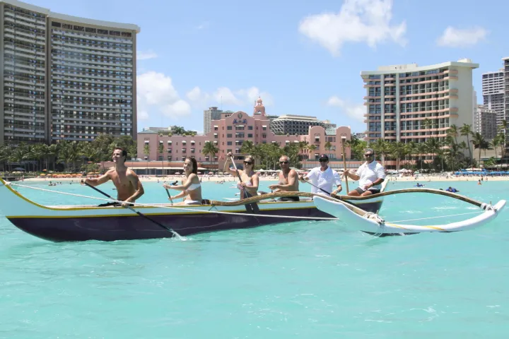 a small boat in a body of water with a city in the background