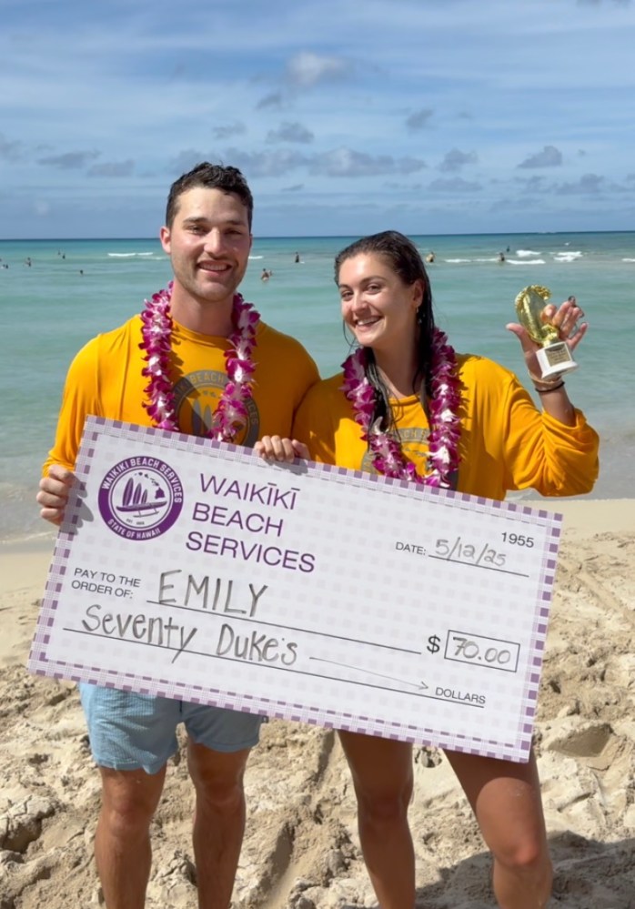 a group of people on a beach holding a sign
