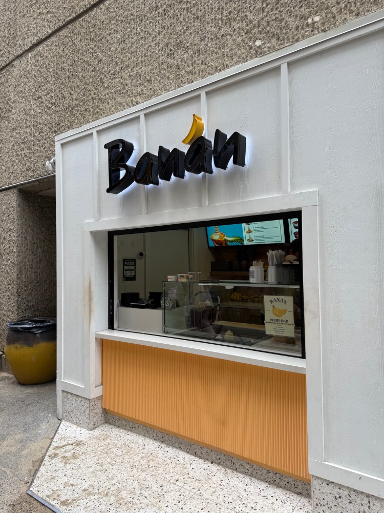 Small shopfront with 'Banan' sign and open counter in a building alley.