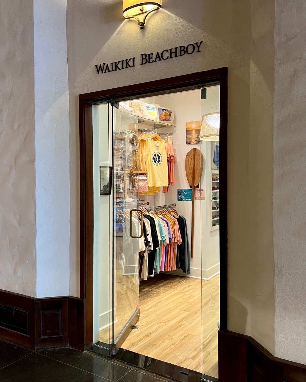 Entrance to Waikiki Beachboy shop with colorful shirts displayed inside.